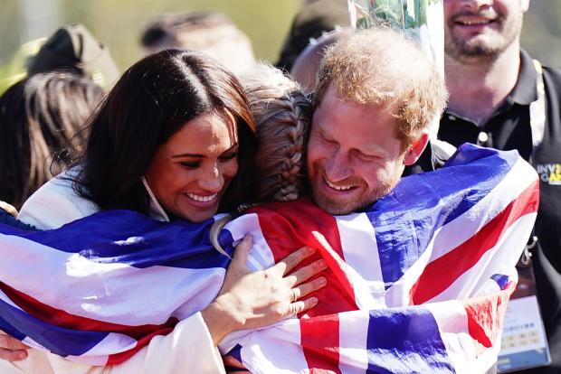 Denbighshire Free Press: The Duke and Duchess of Sussex hug Team United Kingdom competitor Lisa Johnston at the Invictus Games (Aaron Chown/PA)