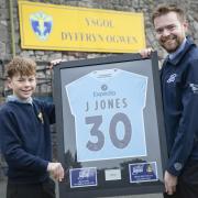 Ysgol Dyffryn Ogwen pupil Noha Wyn Jones receives the framed Wrexham AFC  shirt from Dafydd Jones from IWT. Picture Mandy Jones