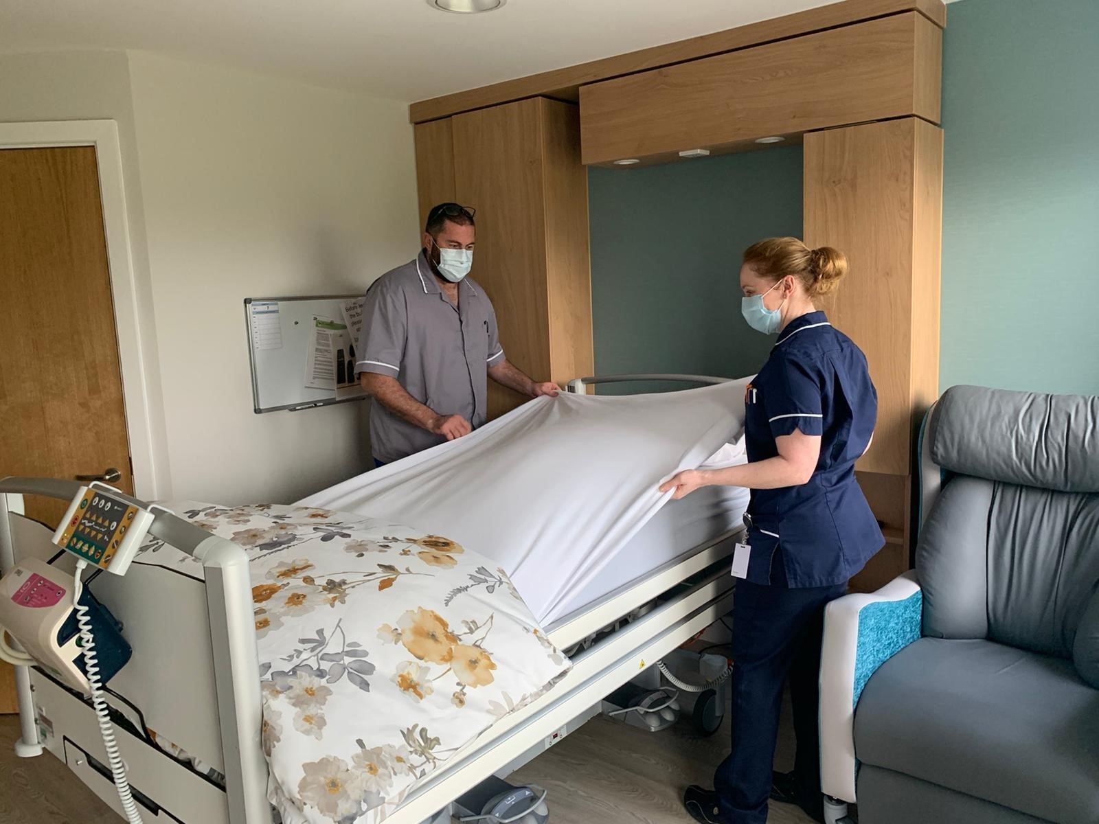 Barry Easton, Healthcare Support Worker, and Emma Parry-Jones, Ward Sister, making up a bed