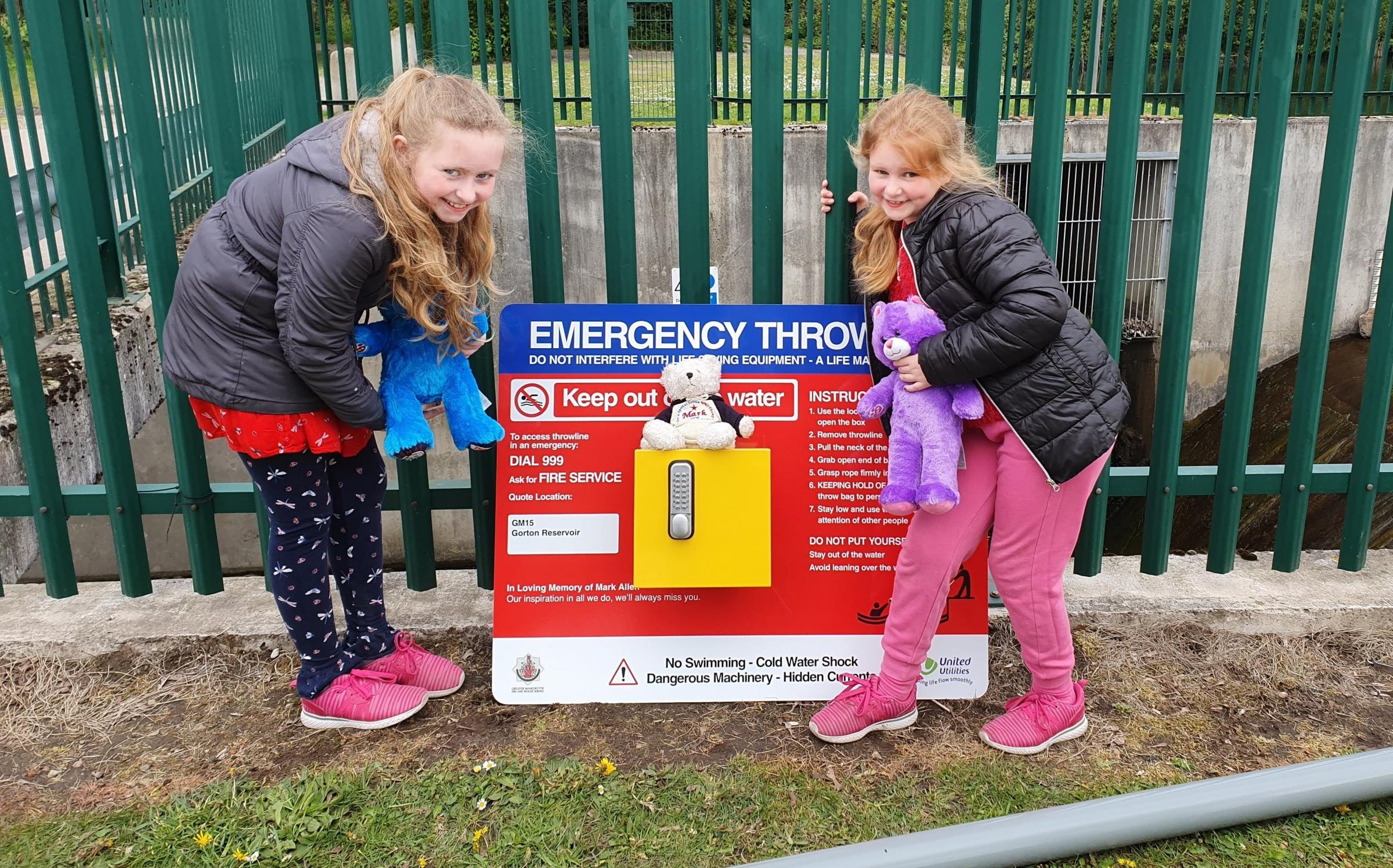 Mark Allens sisters, Caitlin and Megan, with a throwline station the familys campaign has helped install at an open water site.