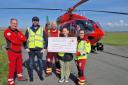 Lucy and Simon present a cheque at the air ambulance base in Caernarfon