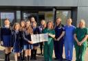 Ysgol Glan Clwyd pupils present £1,700 to the staff of the Enfys Ward