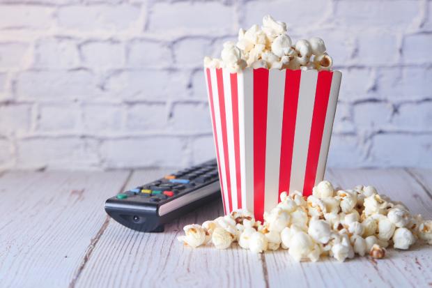 Denbighshire Free Press: A box of popcorn and a TV remote (Canva)