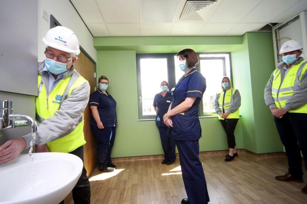 Denbighshire Free Press: Paul Roberts, Wynne Construction Site Manager (left) demonstrates some of the facilities of the newly refurbished Ward 10 at Ysbyty Glan Clwyd, Bodelwyddan to L-R: Bethan Rogers, Ward Manager; Claire Bowen, Matron; Jane Owen, Acting Head of Nursing; Ruth Stiles, BCUHB Planning; and Graham Dickson, Wynne Construction Contracts Manager 