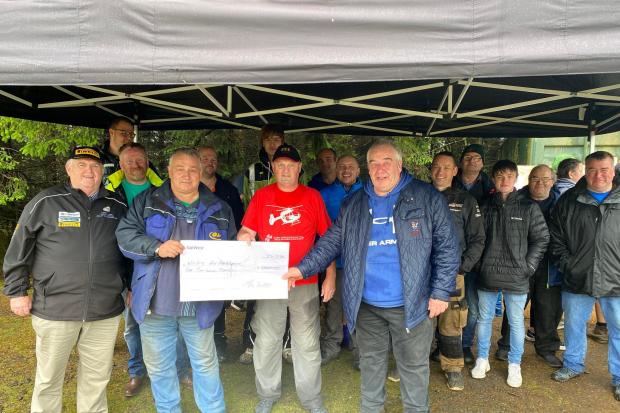 Local North Wales Air Ambulance volunteer Ifor Davies collecting the cheque from Bala and District Motor Club’s vice president Arwel Lloyd Jones and long time NWAA fund raiser Geoff Jones, surrounded by Bala and District Motor Club Members