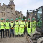 From left: Llyr Gruffydd MS, apprentices Curtis Earp, Zac Hutchinson, Jonathan Evans, Jack Whitworth, Ben Sweetman, William Lewis, Robert Roberts with company chair Hugh Jones and apprentice manager Berwyn Williams in the rear.