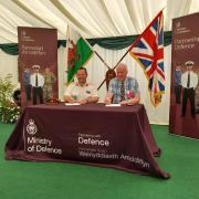 Jones Bros chairman, Huw Jones, right, pictured signing the armed forces covenant