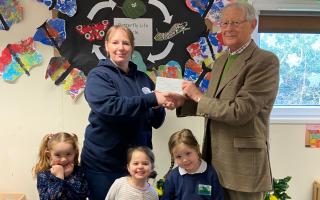 Sir Mark Hudson presenting the cheque to Kaya Ross, manager of Munchkins, with Ede, Jessica and Amelia.